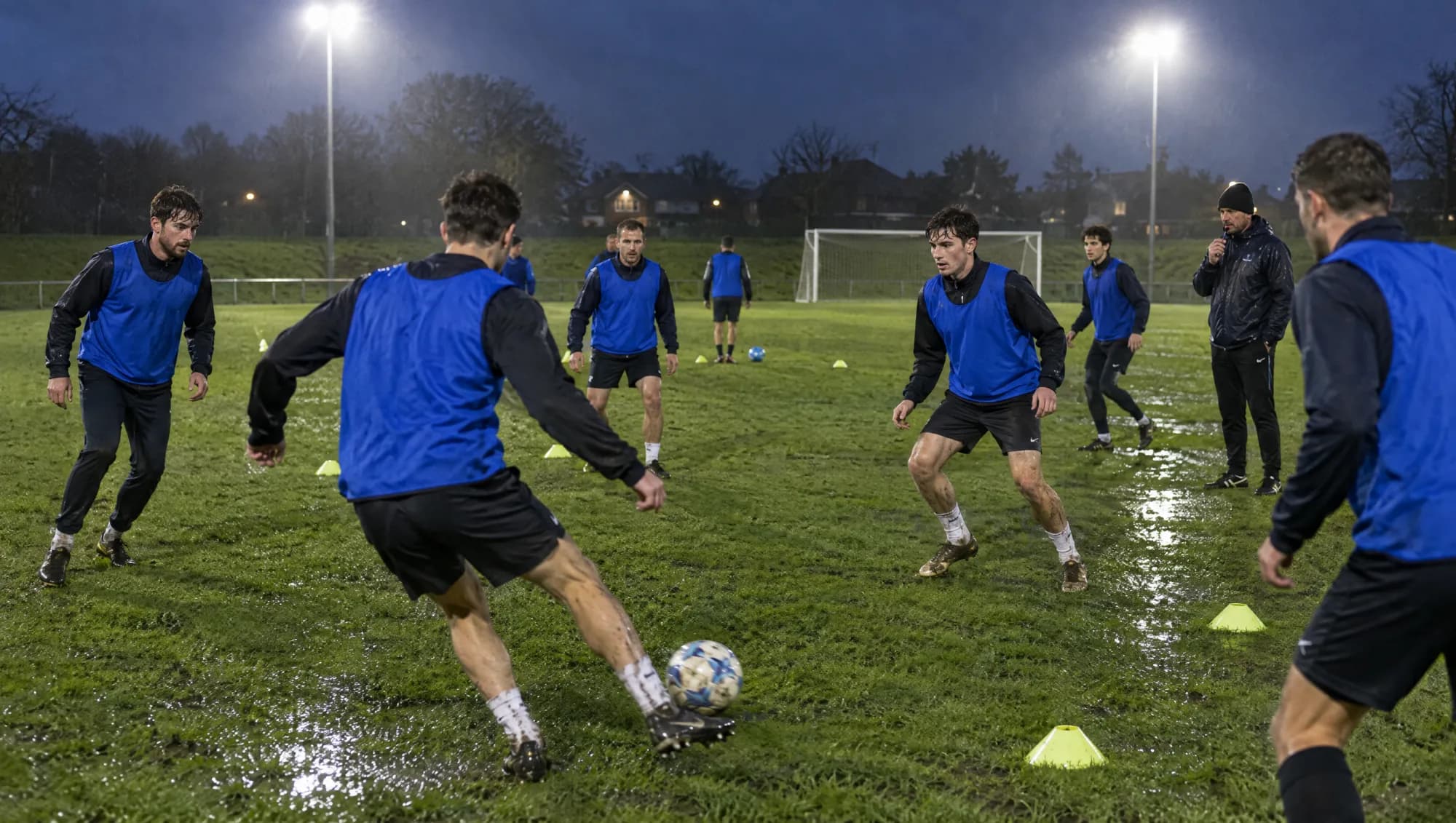 Fußballmannschaft beim Abendtraining unter Flutlicht auf einem Kunstrasenplatz
